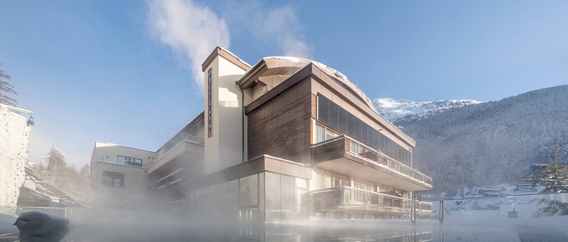Steaming outdoor pool in front of a modern mountain hotel in winter | © johannes brunner