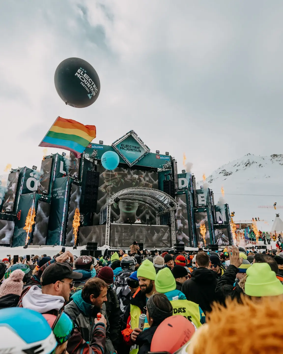 Verschneites Bergfestival mit großer Bühne und vielen Besuchern