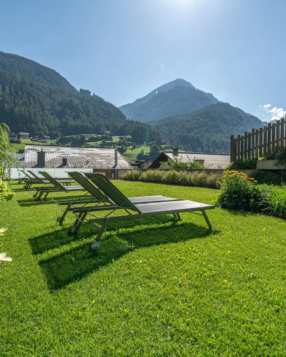 Grüner Rasen mit Liegestühlen vor Alpenpanorama | © johannes brunner