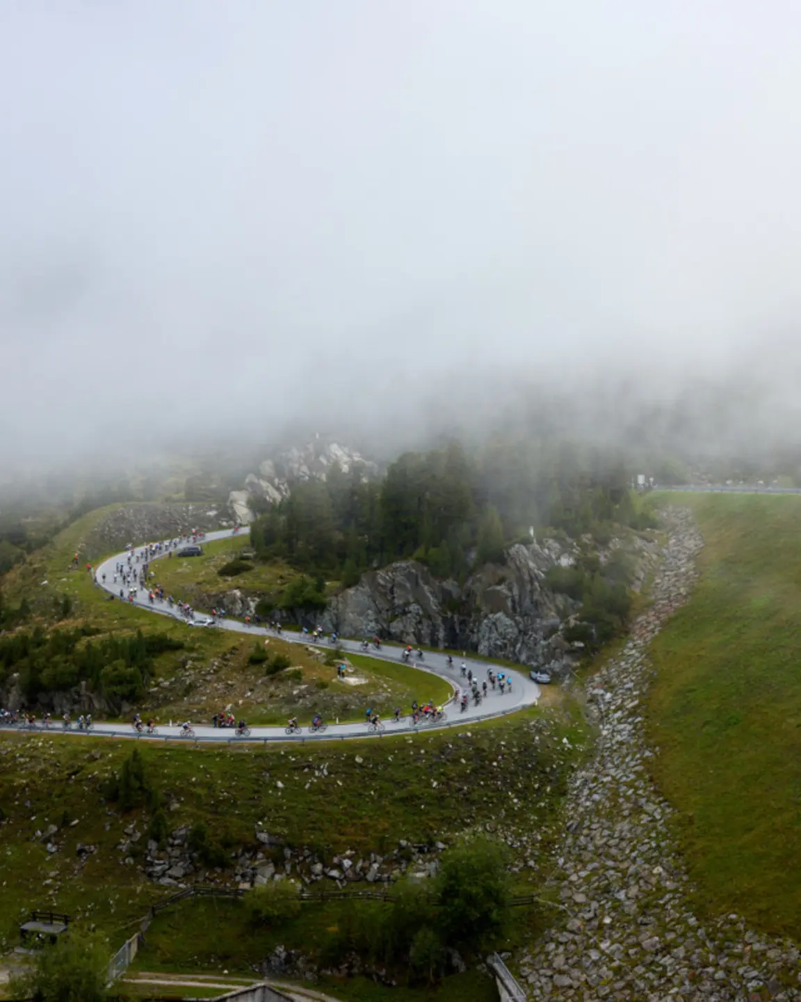 Radfahrer auf nebeliger Serpentinenstraße im Gebirge | © Christoph Noesig PHOTOGRAPHY