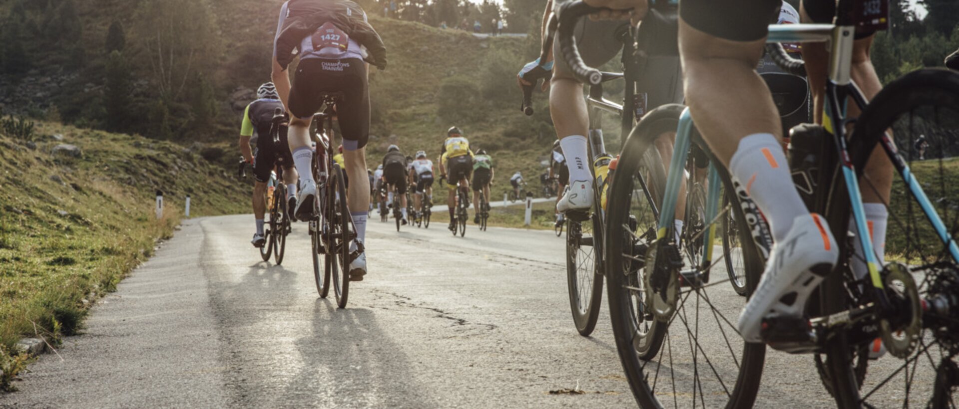 Group of cyclists on a mountain road at sunrise | © © Lukas Ennemoser