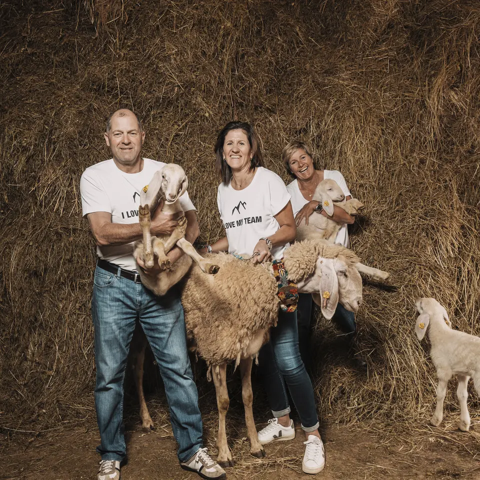 Farm family with sheep and lambs in the hay barn | © ROSSNER-Dominik Fotografie & Film