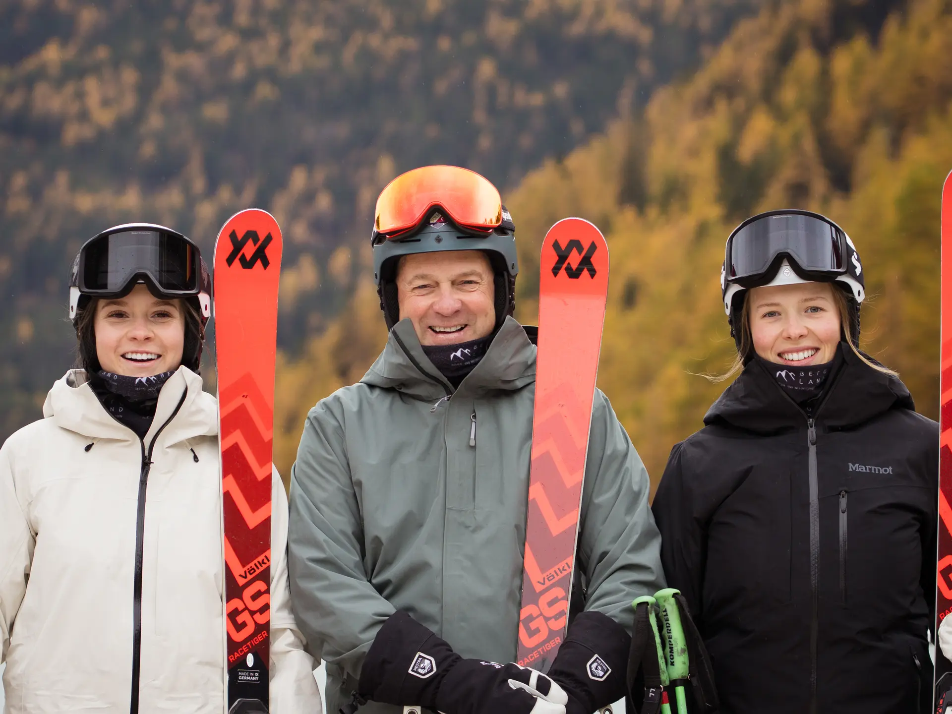 Lächelnde Skifahrer mit Ausrüstung vor Herbstwald | © J.K.