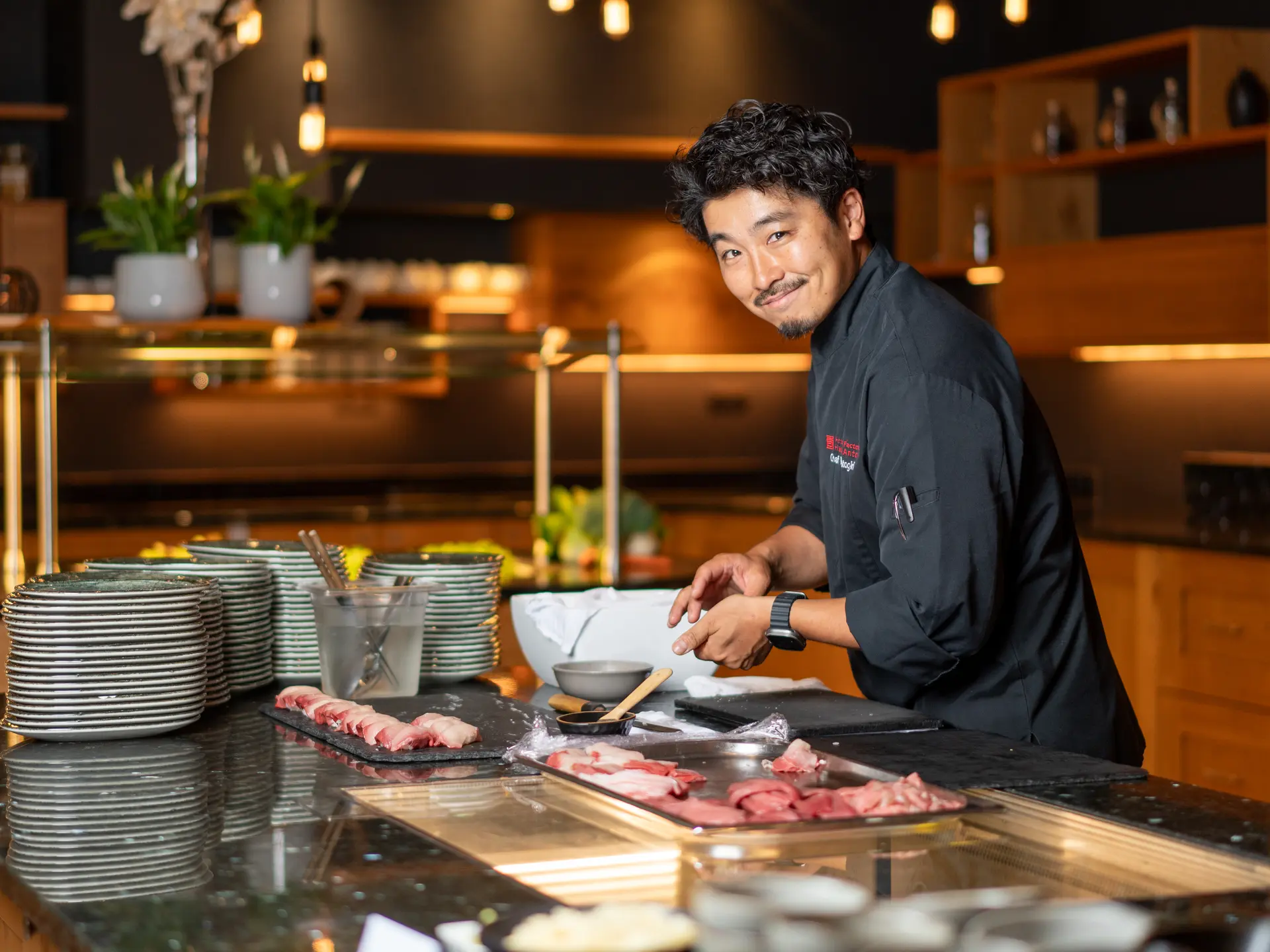 Smiling Asian chef preparing sushi at the counter | © johannes brunner