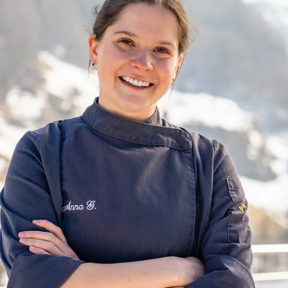 Lächelnde Köchin in Kochjacke vor Winterlandschaft | © J.K.